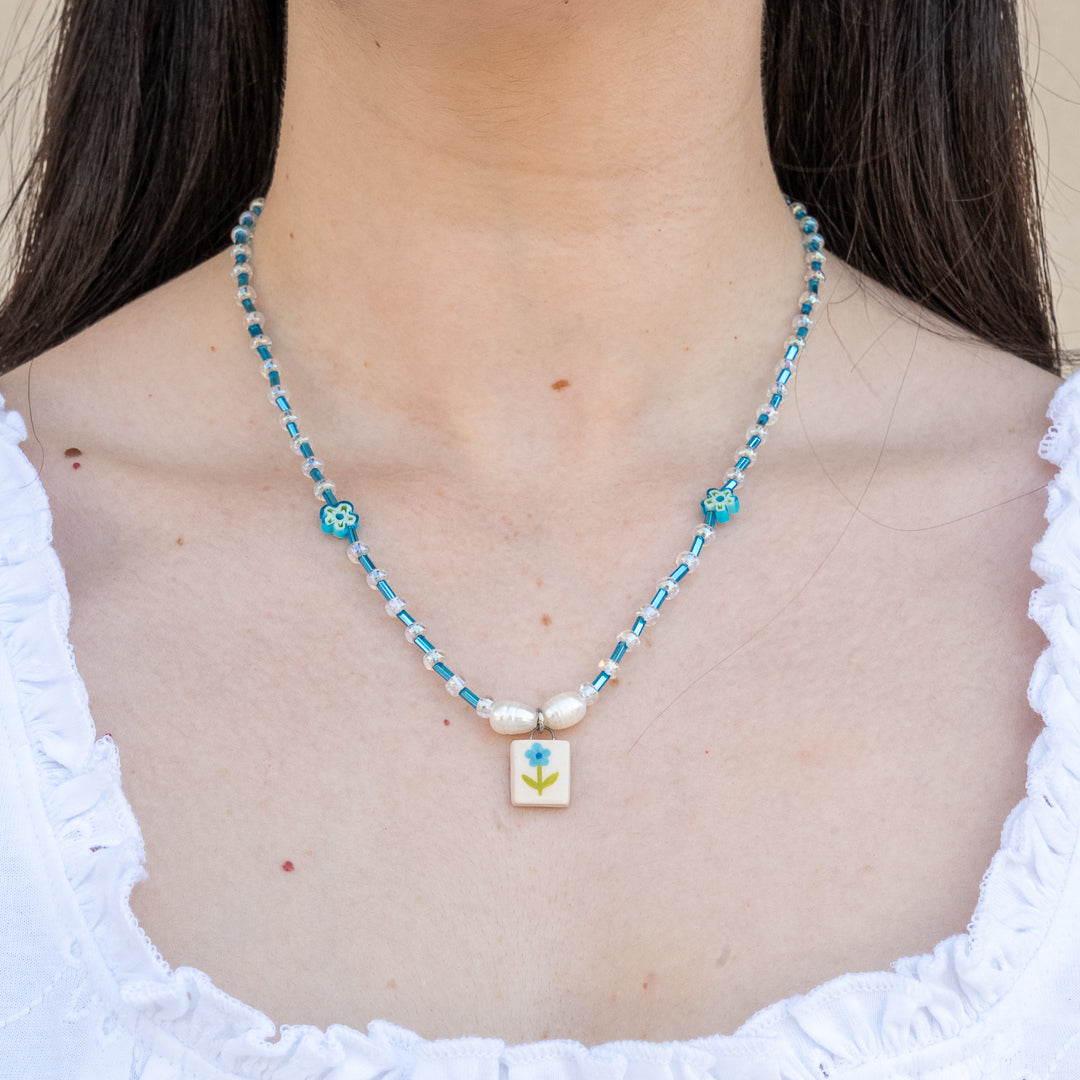 Collana con perline e ciondolo fiorellino