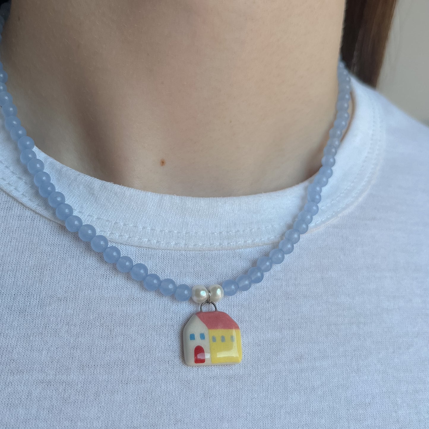 Collana azzurra con ciondolo casetta gialla