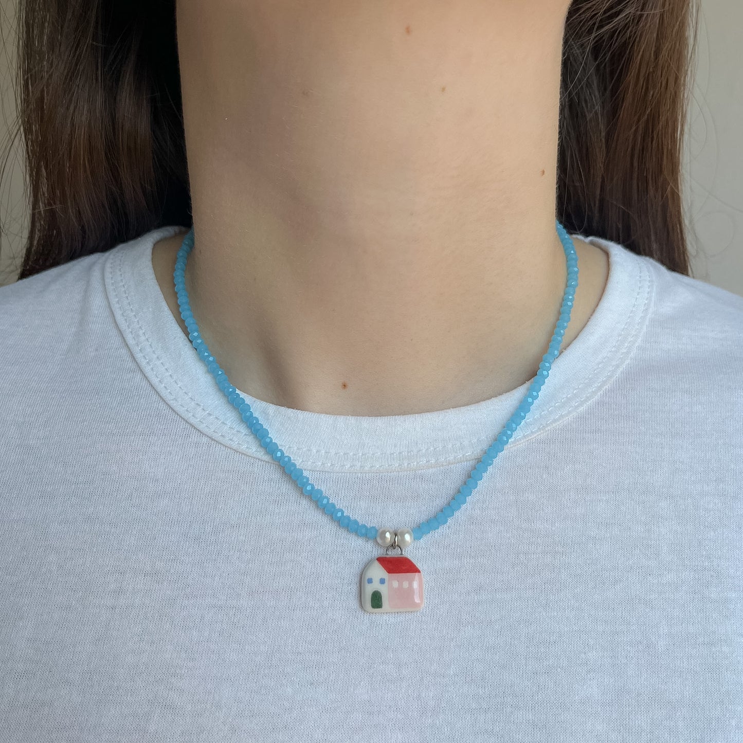 Collana azzurra con ciondolo casetta rosa