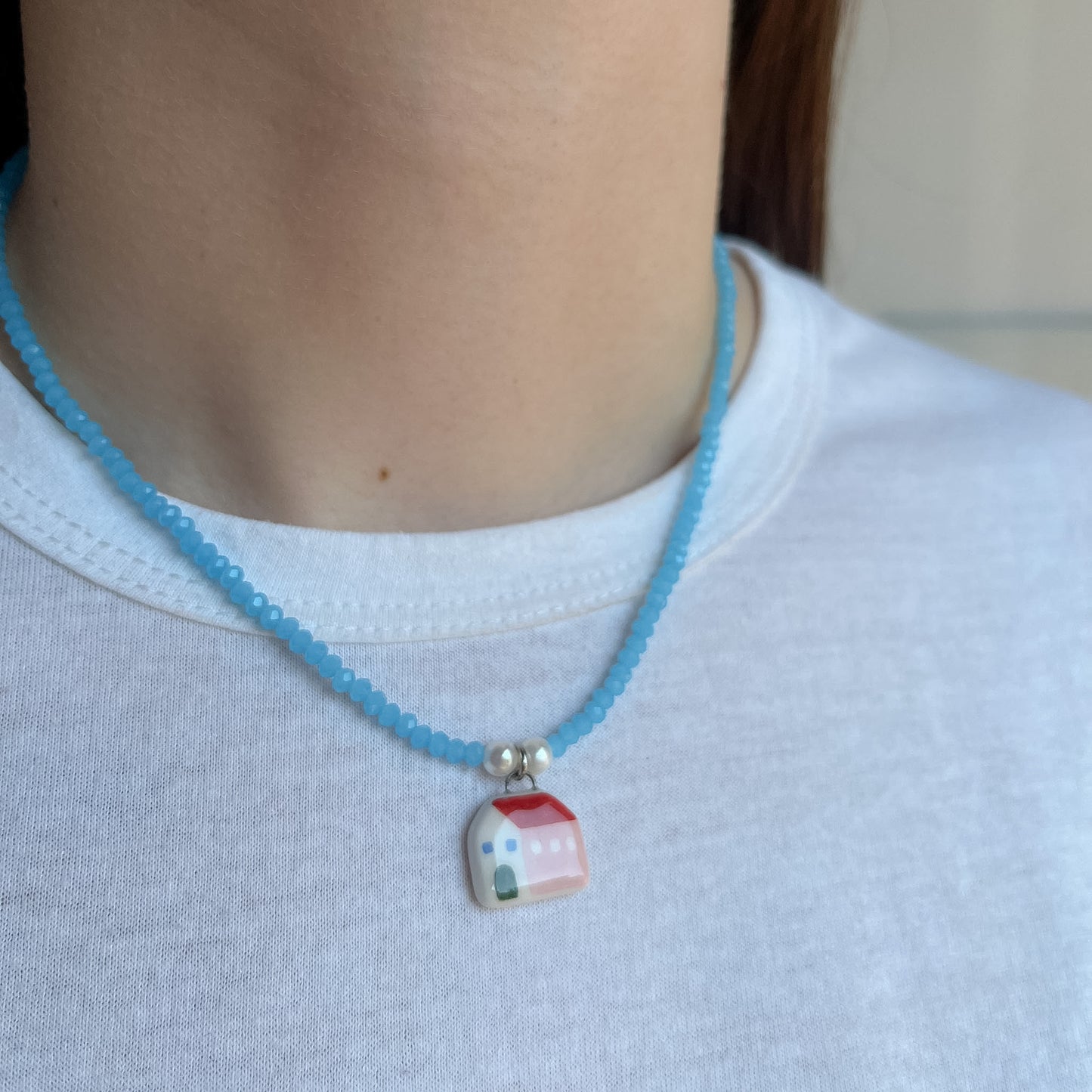 Collana azzurra con ciondolo casetta rosa