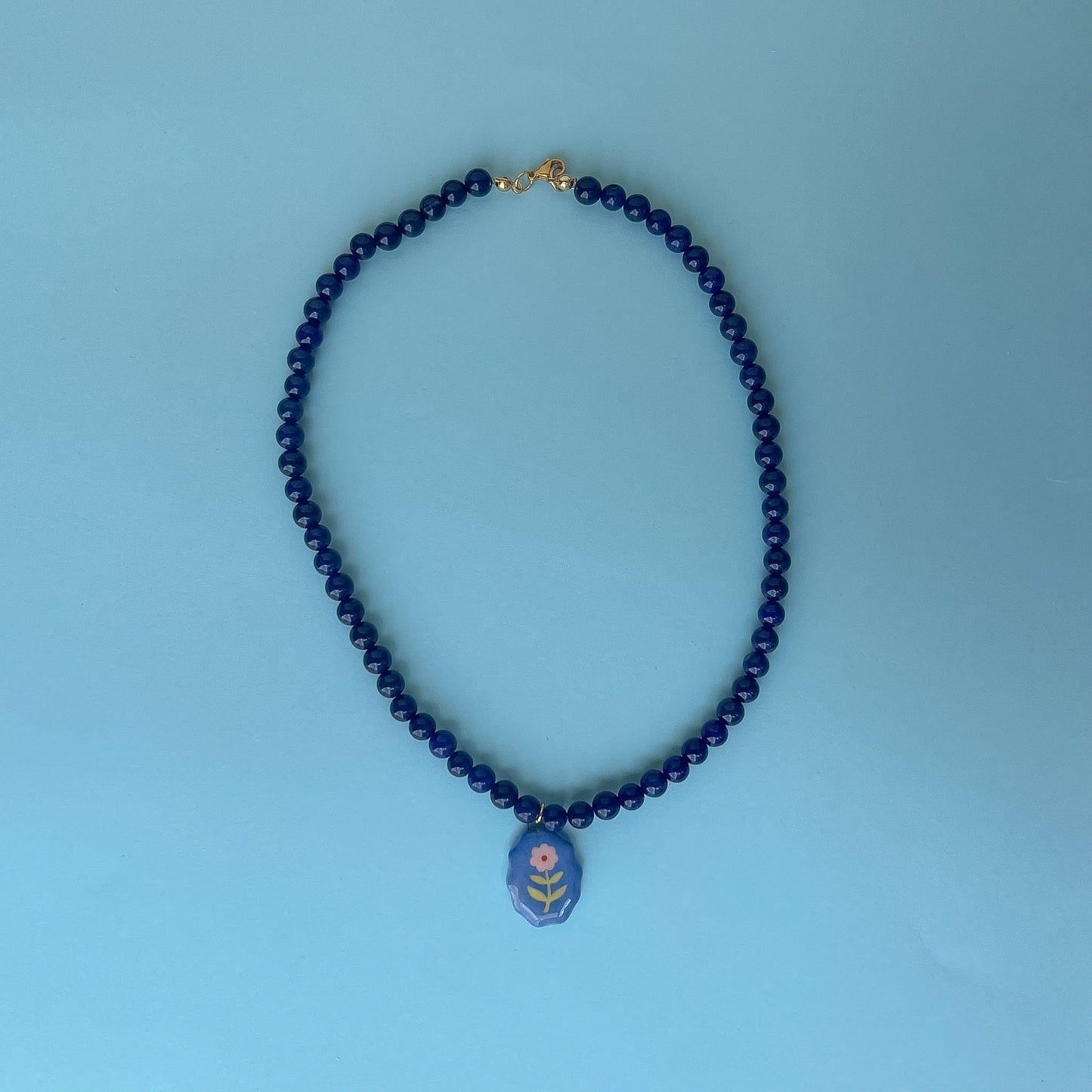 Collana blu con medaglietta fiorellino